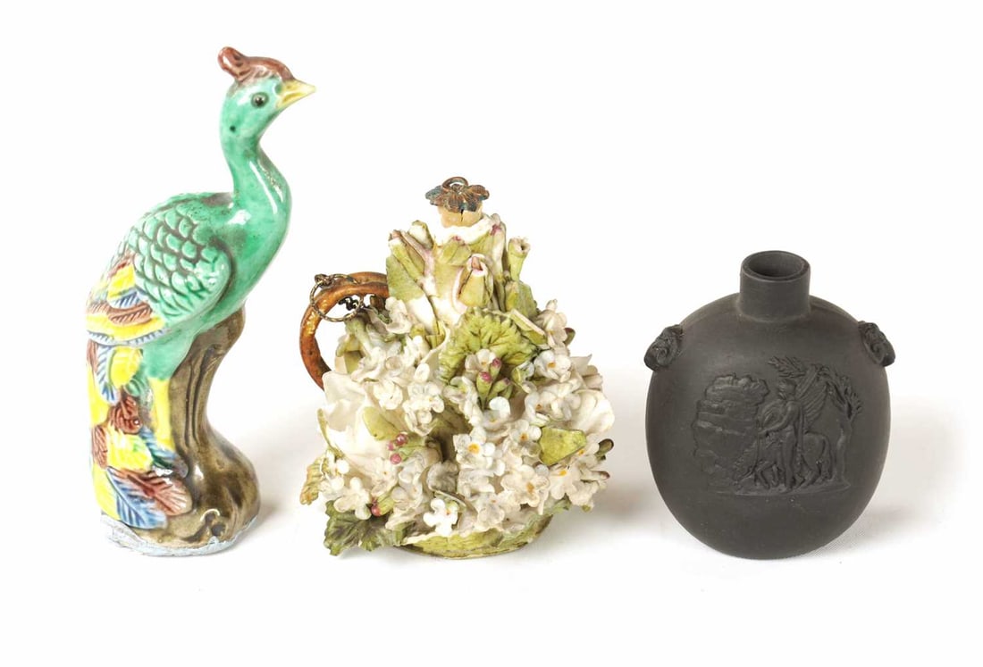 A WEDGWOOD MINIATURE BLACK BASALT SNUFF BOTTLE: A WEDGWOOD MINIATURE BLACK BASALT SNUFF BOTTLE of oval-shouldered form with raised classical figure panels together with a MAJOLICA TYPE ORNAMENTAL BIRD and A FLORALLY ENCRUSTED PERFUME BOTTLE (3) Wed
