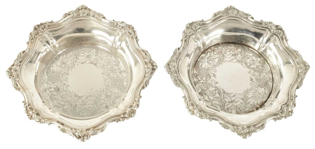 A PAIR OF LATE GEORGIAN SHEFFIELD PLATE WINE BOTTLE COASTERS: A PAIR OF LATE GEORGIAN SHEFFIELD PLATE WINE BOTTLE COASTERS with scalloped and ribbed leaf cast borders enclosing engraved centres - on hardwood bases. 20.5cm diameter In very nice condition with no