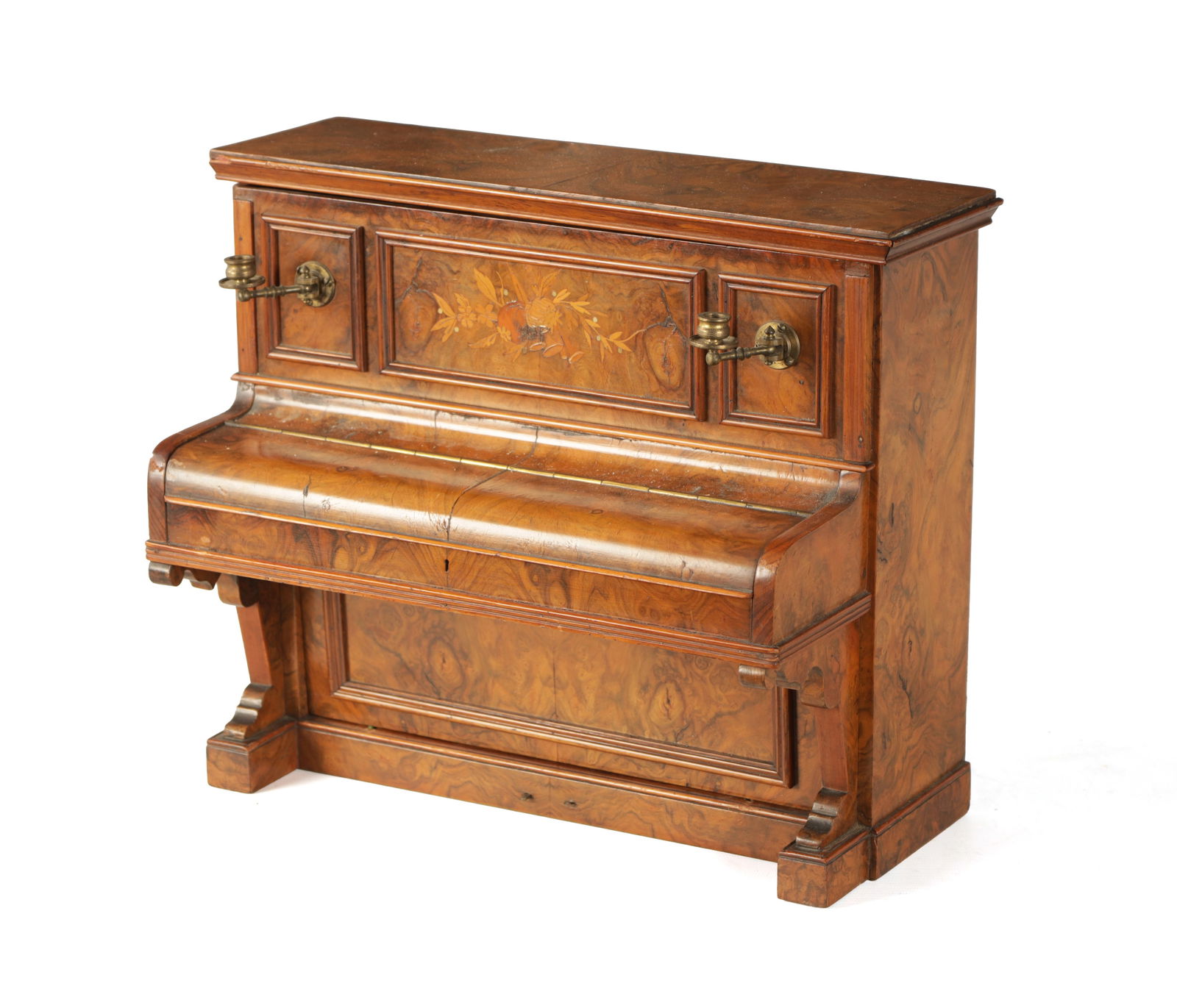 A 19TH CENTURY FIGURED WALNUT CIGAR COMPENDIUM FORMED AS AN UPRIGHT PIANO: A 19TH CENTURY FIGURED WALNUT CIGAR COMPENDIUM FORMED AS AN UPRIGHT PIANO decorated with marquetry panel to the front and adjustable candelabra. having a hinged top with tin lined interior and felt li