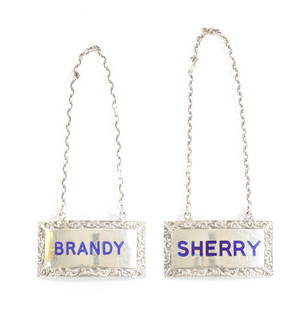 A PAIR OF SILVER AND ENAMEL DECANTER LABELS FOR BRANDY AND SHERRY: A PAIR OF SILVER AND ENAMEL DECANTER LABELS FOR BRANDY AND SHERRY by Turner & Simpson, Birmingham dated 1952. (5cm wide, 3cm high.)