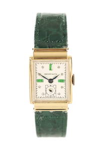 A 1940'S 14CT GOLD TIFFANY & CO. WRISTWATCH: A 1940'S 14CT GOLD TIFFANY & CO. WRISTWATCH on green alligator leather strap, the tank-shaped case enclosing a jewelled champagne dial with subsidiary seconds hand fronting a jewelled manuel wind