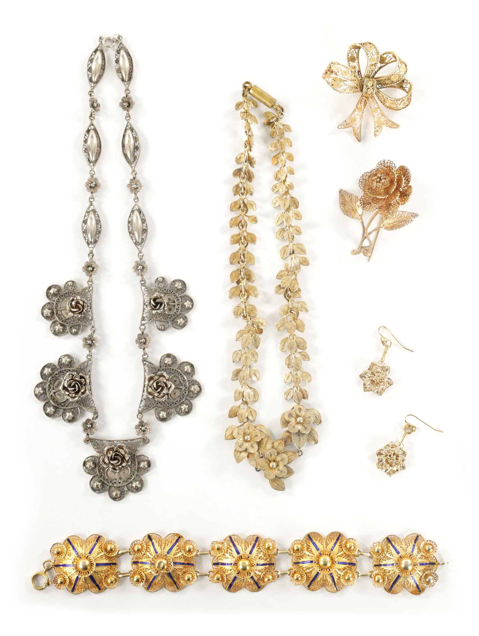 A COLLECTION OF VINTAGE SILVER AND SILVER GILT JEWELLERY: A COLLECTION OF VINTAGE SILVER AND SILVER GILT JEWELLERY of filigree floral designs comprising two necklaces, two brooches, a pair of earrings and a bracelet with blue enamel decoration. (6)