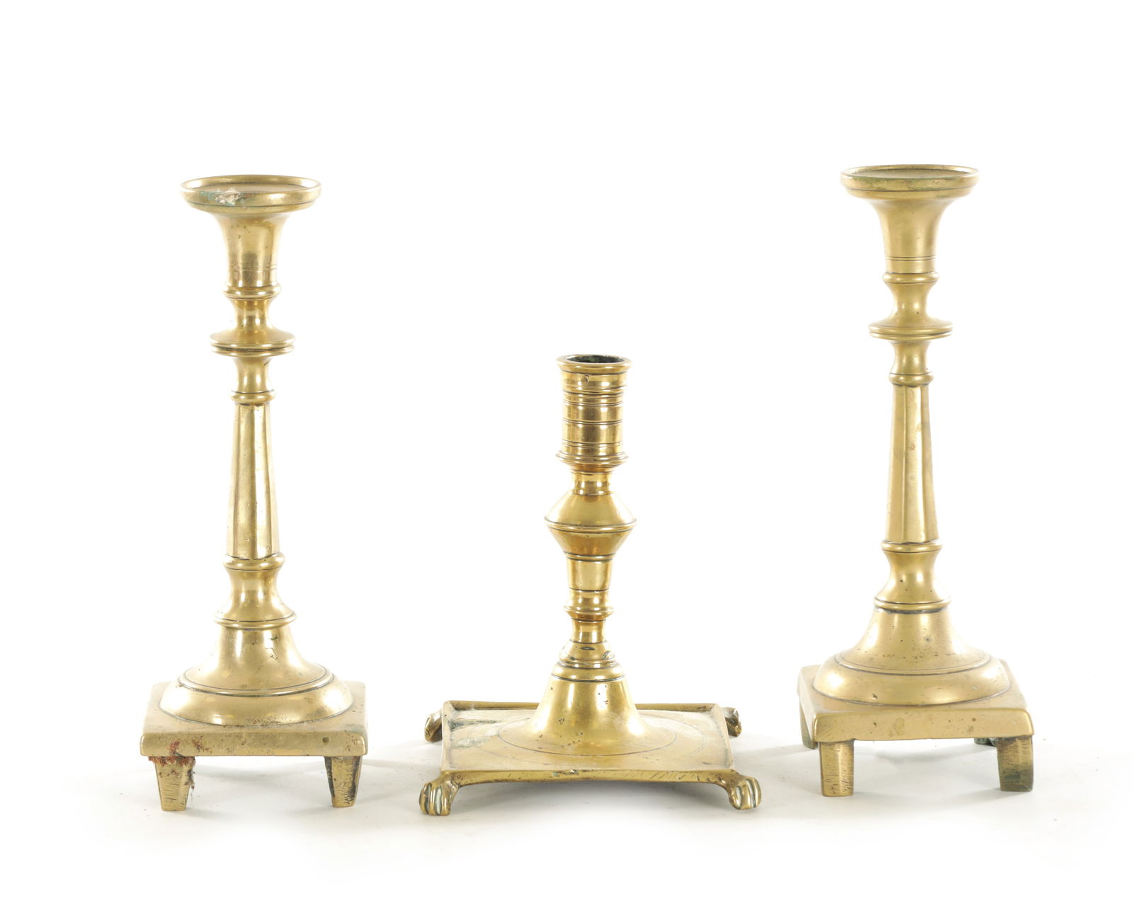 AN EARLY CAST BRASS SPANISH CANDLESTICK TOGETHER WITH A SIMILAR PAIR OF CAST BELL METAL SPANISH: AN EARLY CAST BRASS SPANISH CANDLESTICK TOGETHER WITH A SIMILAR PAIR OF CAST BELL METAL SPANISH CANDLESTICKS (17cm and 24cm high )