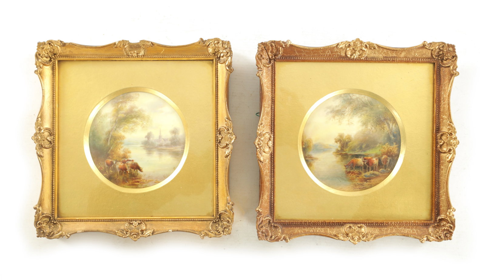 A PAIR OF ROYAL WORCESTER CIRCULAR HANGING PLAQUES BY JOHN STINTON: A PAIR OF ROYAL WORCESTER CIRCULAR HANGING PLAQUES BY JOHN STINTON depicting cows watering by a River - signed mounted in glazed gilt swept frames; puce marks on the reverse entitled 'On The Torne' (p