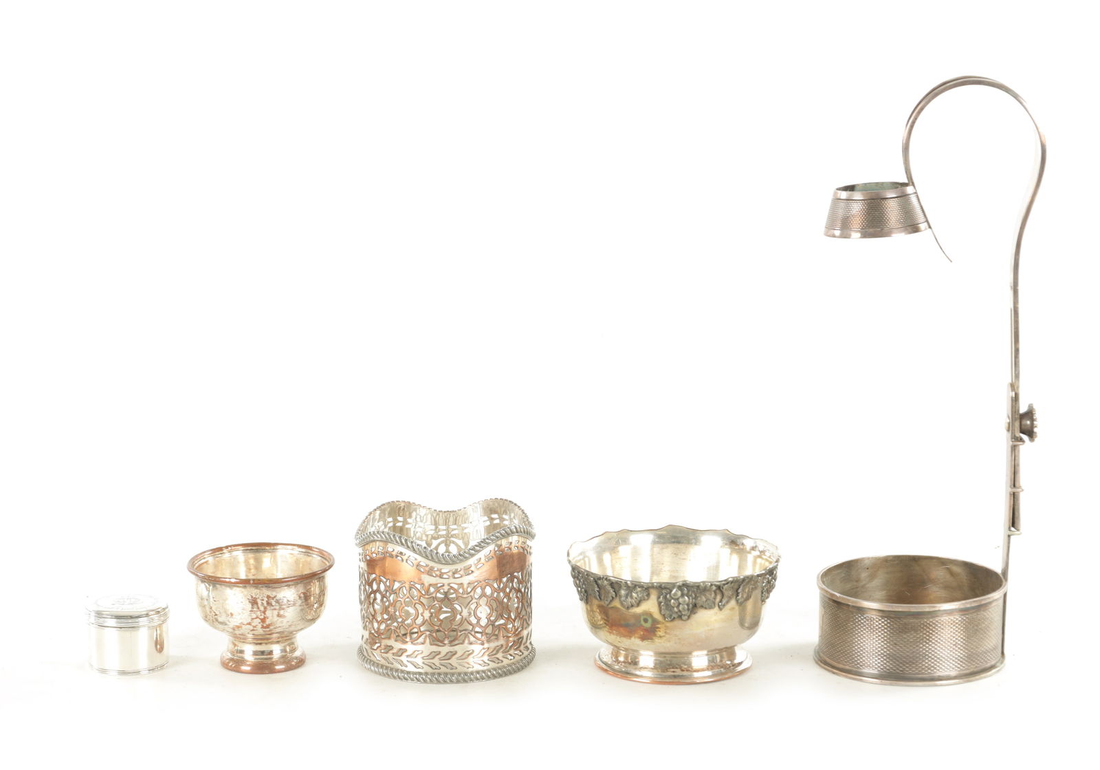 A GEORGE III SILVER PASTE POT: A GEORGE III SILVER PASTE POT the screw on top with engraved motto and central motif AN ADJUSTABLE ELKINGTON PLATE WINE BOTTLE POURER, A SHEFFIELD PLATE PIERCED WINE BOTTLE COASTER and TWO SMALL BOWLS