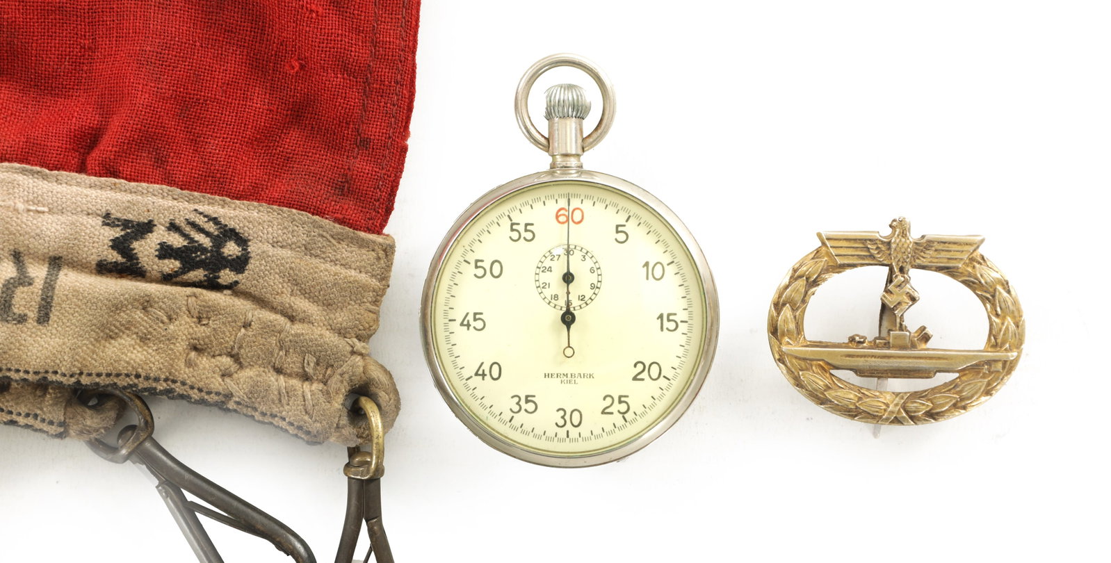 A GERMAN THIRD REICH U-BOAT TORPEEDO TIMER STOPWATCH TOGETHER WITH NAVAL SUBMARINE BADGE AND NAZI: A GERMAN THIRD REICH U-BOAT TORPEEDO TIMER STOPWATCH TOGETHER WITH NAVAL SUBMARINE BADGE AND NAZI NATIONAL NAVAL WAR FLAG. The Stopwatch being a fine example with a white enamel dial having Arabic num