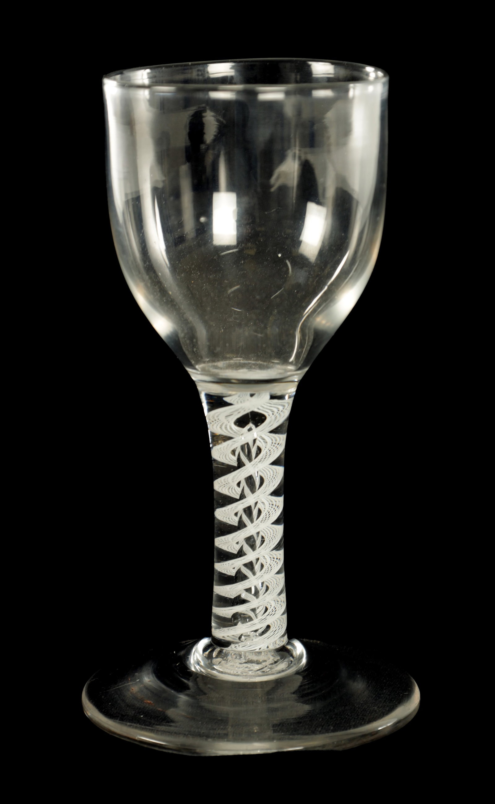 AN 18TH CENTURY STYLE OVERSIZED WINE GLASS: AN 18TH CENTURY STYLE OVERSIZED WINE GLASS the slight ogee bowl on a double opaque cable twist stem and flat foot. (17cm high)