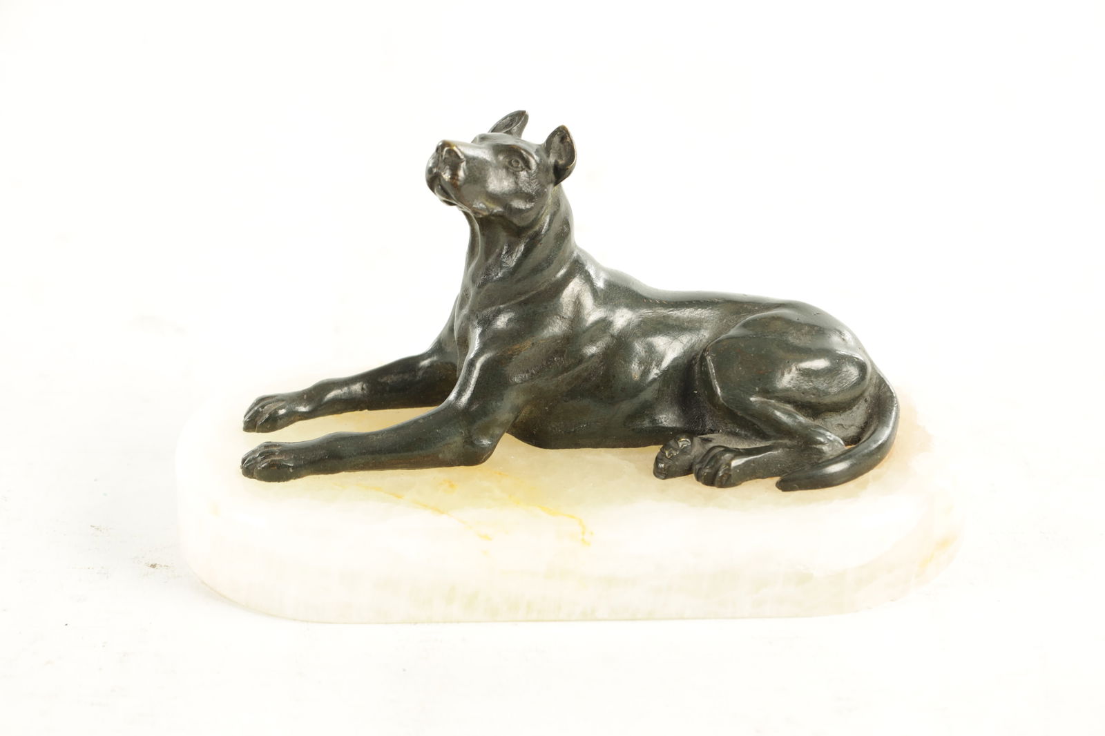 A 19TH CENTURY FRENCH BRONZE AND WHITE ONYX RECUMBENT DOG DESK PAPERWEIGHT: A 19TH CENTURY FRENCH BRONZE AND WHITE ONYX RECUMBENT DOG DESK PAPERWEIGHT with dark green patinated finish. (16.5cm width and 9cm high)