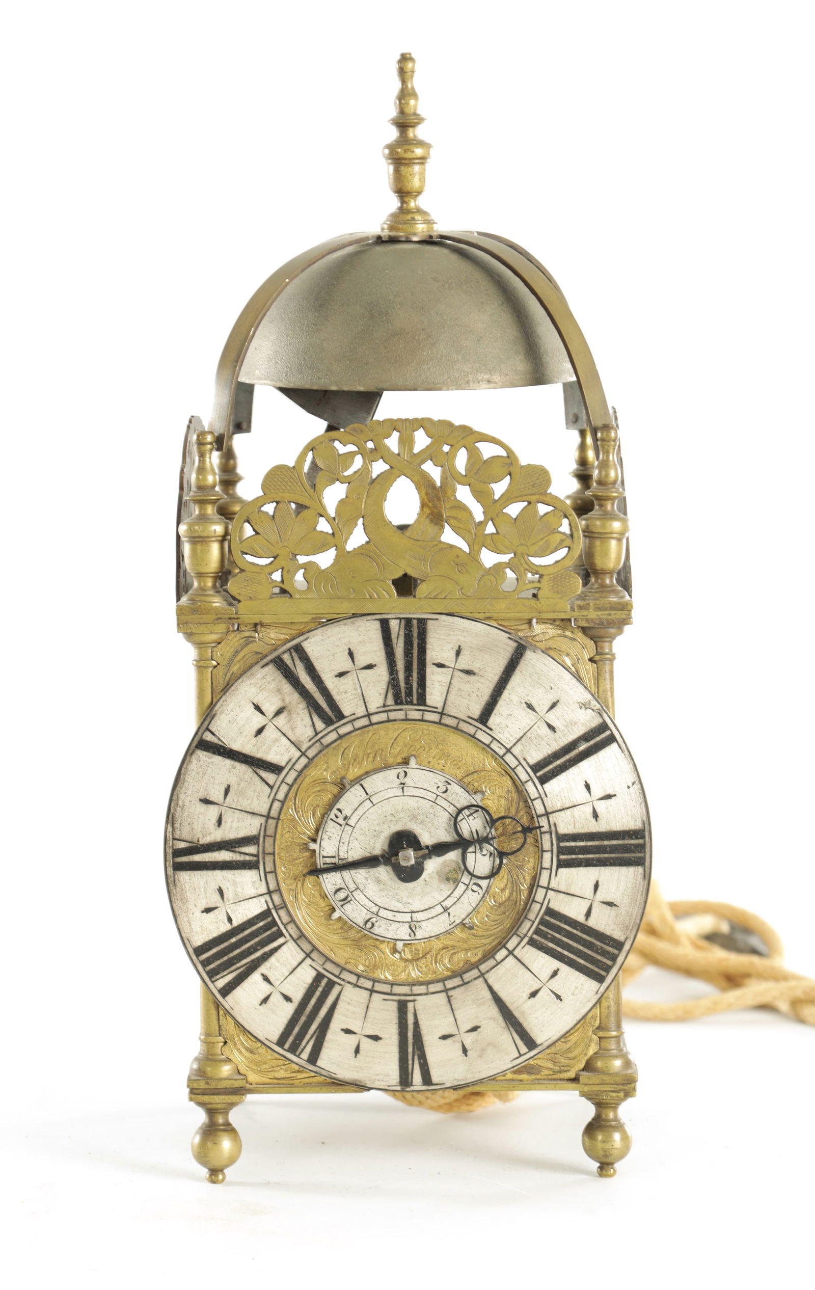 JOHN GOODMAN, AN EARLY 18TH CENTURY BRASS LANTERN CLOCK: JOHN GOODMAN, AN EARLY 18TH CENTURY BRASS LANTERN CLOCK, having a posted frame and large steel bell above pierced dolphin engraved frets, the 6 1/2" silvered Roman chapter ring surrounding a signed sc