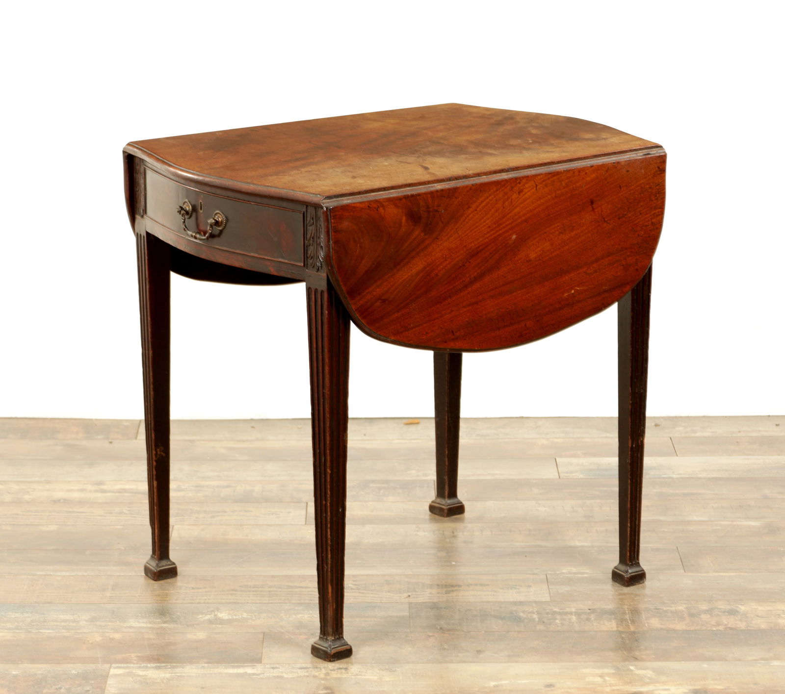 A GOOD GEORGE III FIGURED MAHOGANY PEMBROKE TABLE IN THE MANNER OF THOMAS CHIPPENDALE: A GOOD GEORGE III FIGURED MAHOGANY PEMBROKE TABLE IN THE MANNER OF THOMAS CHIPPENDALE with serpentine shaped top having hinged sides, above frieze drawers and raised on fluted tapering square legs wit