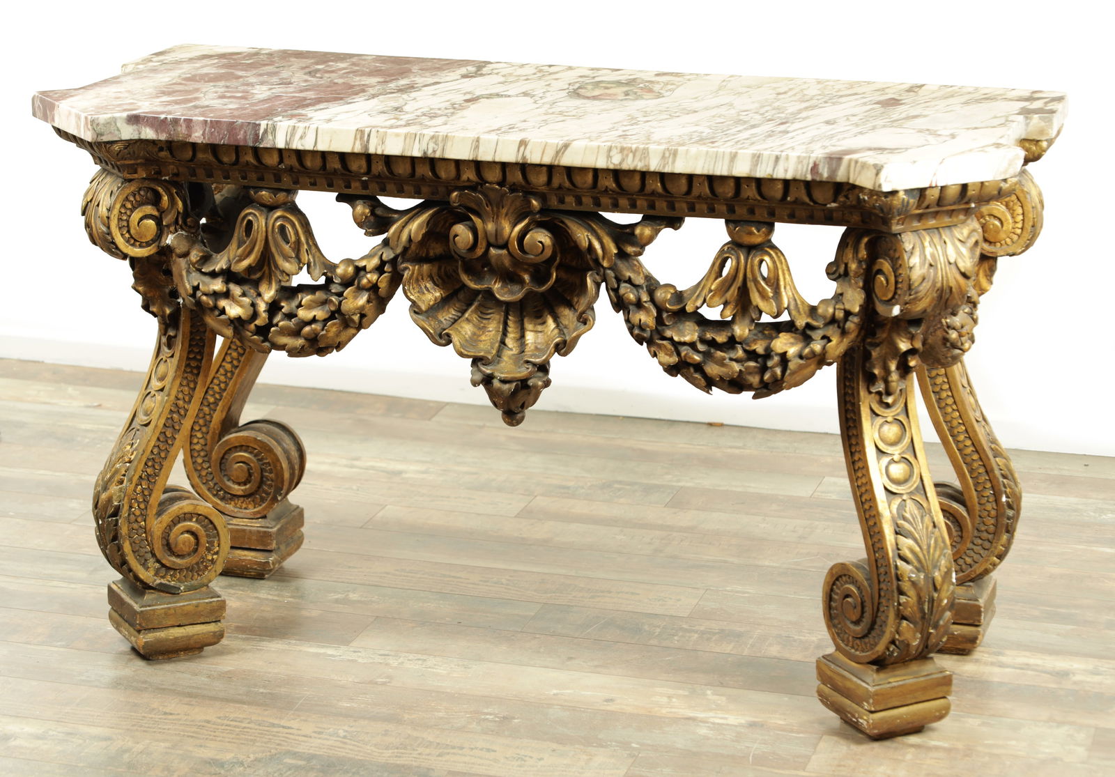 A DECORATIVE 19TH CENTURY GILT MARBLE TOPPED PIER TABLE IN THE MANNER OF WILLIAM KENT: A DECORATIVE 19TH CENTURY GILT MARBLE TOPPED PIER TABLE IN THE MANNER OF WILLIAM KENT having an 18th-century veined marble top above a gilt work boldly shaped base with shell centre and swag work deco