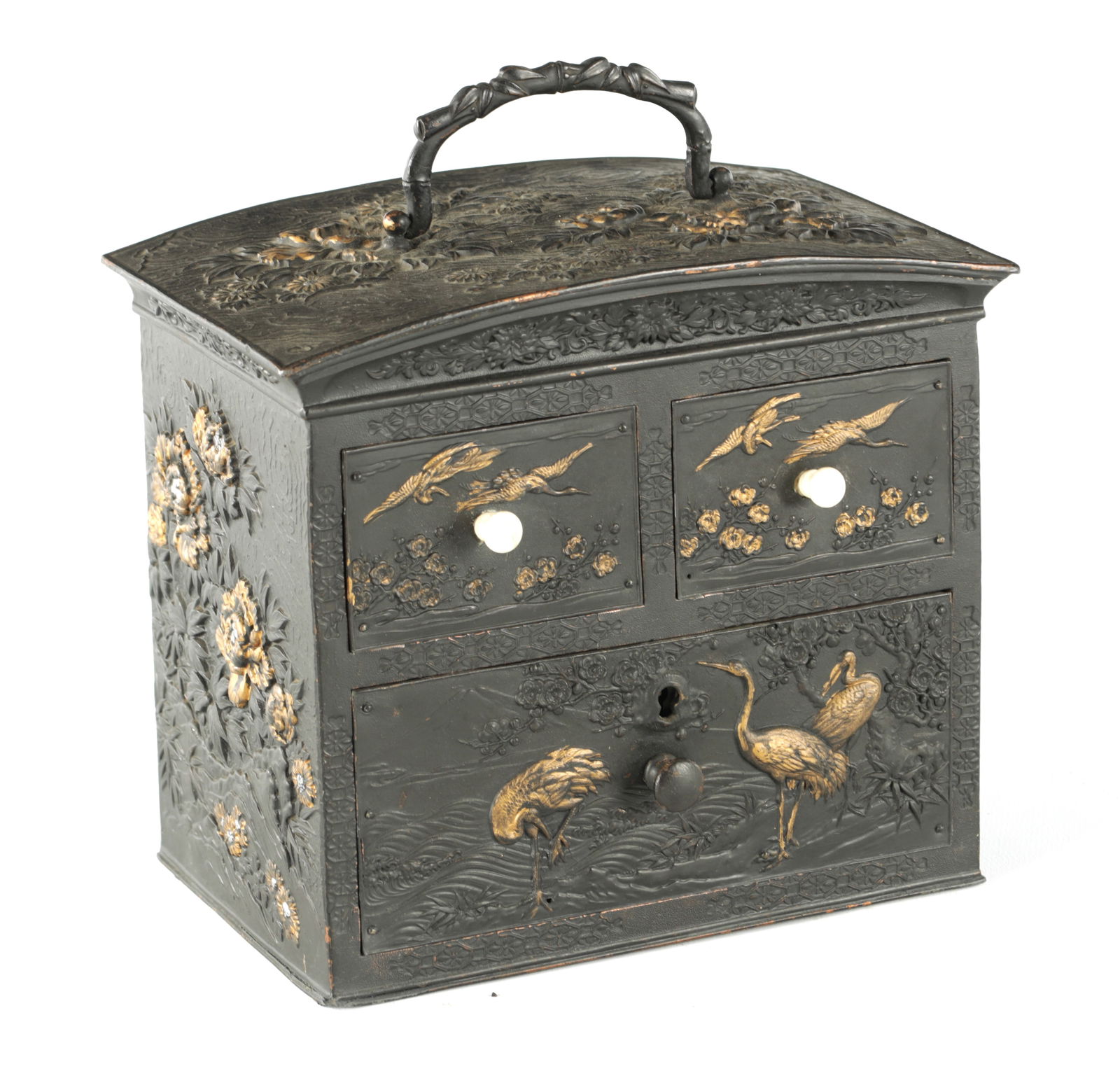 A LATE 19TH CENTURY JAPANESE GILT HIGHLIGHTED BRONZED TABLE CABINET: A LATE 19TH CENTURY JAPANESE GILT HIGHLIGHTED BRONZED TABLE CABINET with two small and one long drawers, two with bone handles, embossed with flower sprays and storks, the domed top with hinged handle