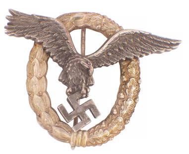A WW2 GERMAN LUFTWAFFE PILOT'S BADGE: A WW2 GERMAN LUFTWAFFE PILOT'S BADGE with riveted eagle enclosed by a wreath, marked "A" for f.w. Assmann & Sohne (7cm wide 5.5cm high)