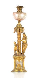 A LATE 19TH CENTURY GILT METAL FIGURAL OIL LAMP BASE OF GOTHIC DESIGN: A LATE 19TH CENTURY GILT METAL FIGURAL OIL LAMP BASE OF GOTHIC DESIGN with double burner and pink glass reservoir above a mother and child beneath a palm tree on a gothic style circular base (73cm