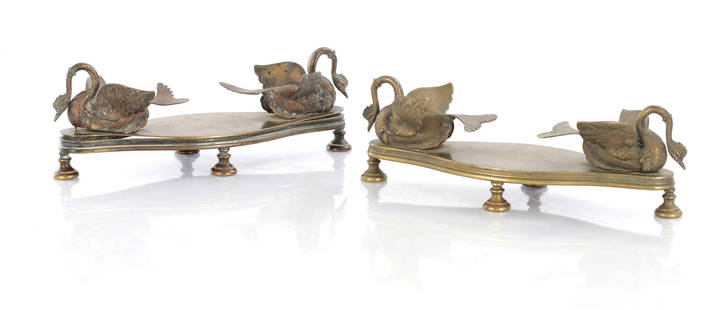 A PAIR OF 19TH CENTURY BRONZE DESK STANDS: A PAIR OF 19TH CENTURY BRONZE DESK STANDS with shaped bases having mythical swan serpents raised on bun feet. (29cm wide 9.5cm high )