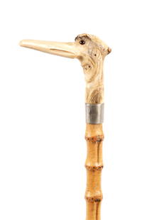 A 19TH CENTURY CARVED HORN GROTESQUE WALKING STICK: A 19TH CENTURY CARVED HORN GROTESQUE WALKING STICK modelled as a man's head with protruding nose inset glass eyes on a metal collar and whangee shaft. (89.5cm long)