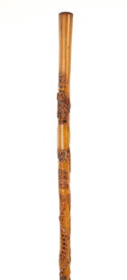 A LATE 19TH CENTURY MEXICAN FOLK ART WALKING CANE: A LATE 19TH CENTURY MEXICAN FOLK ART WALKING CANE with the national shield of Mexico at the top, depicting an eagle perched on a prickly pear cactus devouring a rattlesnake, above raised carvings of a