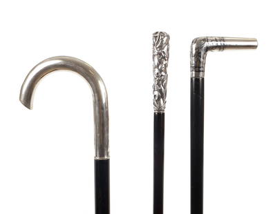 A COLLECTION OF THREE SILVER TOPPED WALKING STICKS: A COLLECTION OF THREE SILVER TOPPED WALKING STICKS comprising an art nouveau example with embossed fleur-de-lis pattern, a crook handle with engraved initials and another with L-shaped niello handle;