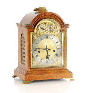 A LATE 19TH CENTURY GERMAN EIGHT BELL QUARTER CHIMING BRACKET CLOCK: A LATE 19TH CENTURY GERMAN EIGHT BELL QUARTER CHIMING BRACKET CLOCK, the oak case with gilt brass fish scale sound frets and brass moulded door enclosing a 7" arched brass dial with gilt spandrels