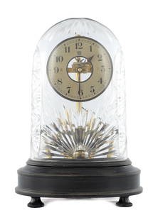 AN EARLY 20TH CENTURY FRENCH ELECTRIC BULLE MANTEL CLOCK: AN EARLY 20TH CENTURY FRENCH ELECTRIC BULLE MANTEL CLOCK having a silvered dial, the battery run movement with a magnetic impulse pendulum displayed under a cut glass dome on an ebonised oval wooden