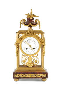 REVEL, PARIS. A LATE 19TH CENTURY FRENCH ROUGE MARBLE AND ORMOLU FOUR GLASS MANTEL CLOCK: REVEL, PARIS. A LATE 19TH CENTURY FRENCH ROUGE MARBLE AND ORMOLU FOUR GLASS MANTEL CLOCK, with urn finial above a glazed ormolu case on rouge marble base, the floral painted enamel dial with Arabic nu