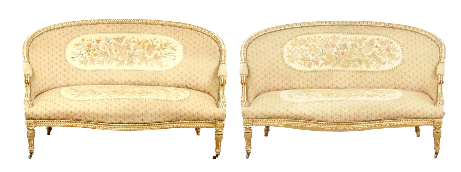 A PAIR OF 19TH CENTURY GILTWOOD AND PAINTED COUNTRY HOUSE SETTEES IN THE MANNER OF JOHN HOWARD: A PAIR OF 19TH CENTURY GILTWOOD AND PAINTED COUNTRY HOUSE SETTEES IN THE MANNER OF JOHN HOWARD with embroidered coverings and leaf-carved frame having scrolled arm supports and serpentine fronts raise