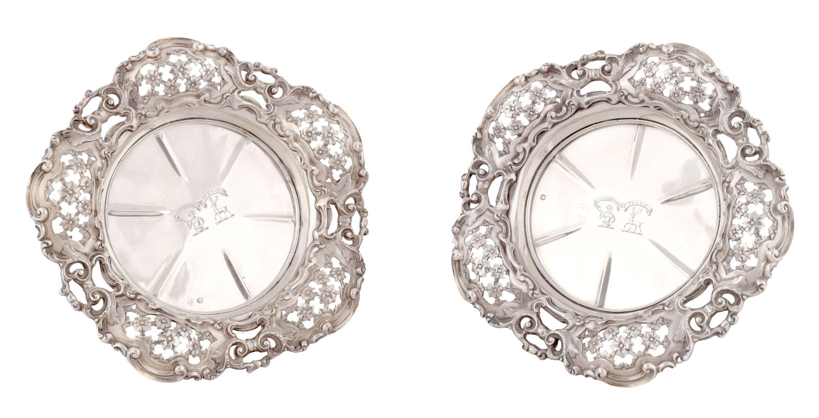 JOHN MORTIMER & JOHN SAMUEL HUNT A PAIR OF SILVER VICTORIAN BOTTLE COASTERS: JOHN MORTIMER & JOHN SAMUEL HUNT A PAIR OF SILVER VICTORIAN BOTTLE COASTERS rims pierced and cast with flowerhead cartouches, with starburst centres, engraved with a family crest, baize-lined bases, L