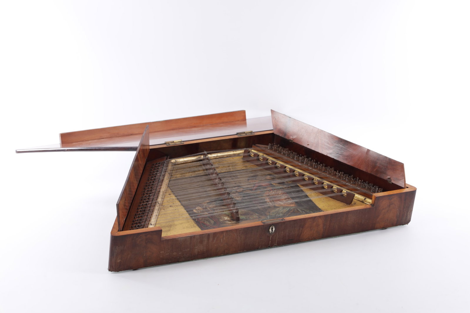 A 19TH CENTURY MAHOGANY DULCIMER: 19TH CENTURY MAHOGANY DULCIMER a trapezoidal hammered dulcimer in a mahogany veneered wooden case with hinged lid panels, multiple string courses over twin bridges, arrays of tuning pins, a painted ce