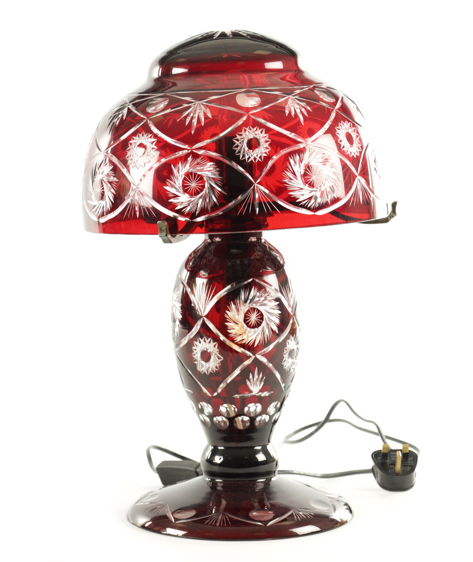 A 2OTH CENTURY BOHEMIAN RUBY RED CUT GLASS LAMP: A 2OTH CENTURY BOHEMIAN RUBY RED CUT GLASS LAMP with lattice spiral work floral cut pattern, on a domed foot. (48cm high)
