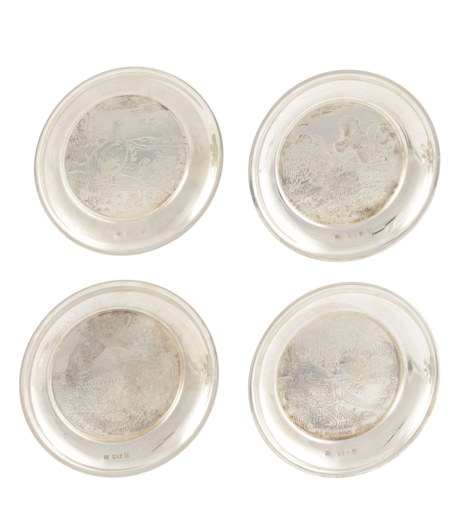 A SET OF FOUR IRISH SILVER GAME BIRD COASTERS: A SET OF FOUR IRISH SILVER GAME BIRD COASTERS with engraved scenes including grouse, quail, partridge and pheasant. Hallmarked Royal Irish Silver Co, Dublin, 1973. Total weight app. 428g. (Diameter 12