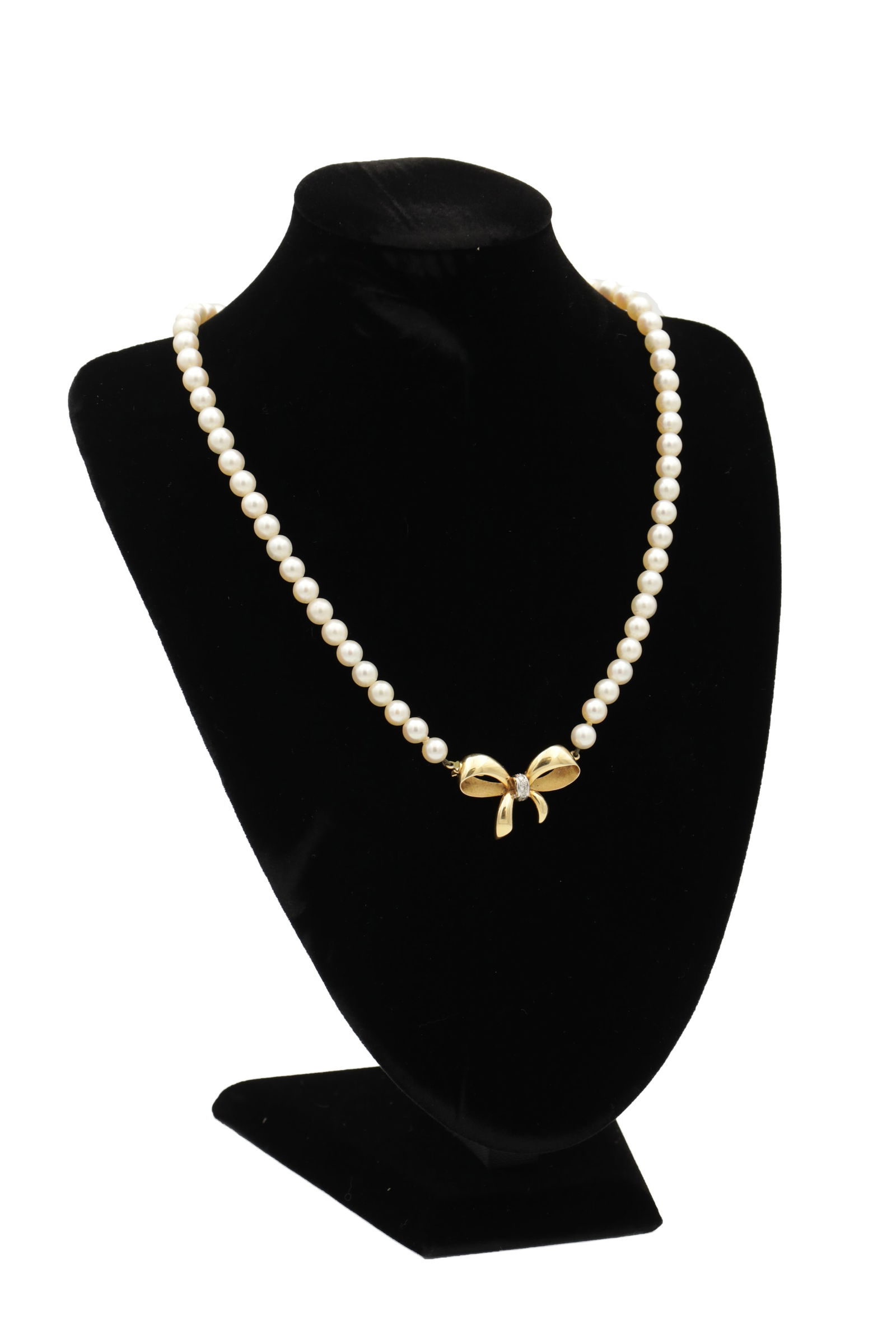 AN 18CT YELLOW GOLD DIAMOND AND PEARL NECKLACE: AN 18CT YELLOW GOLD DIAMOND AND PEARL NECKLACE the 18ct yellow gold bow clasp is set with brilliant cut diamonds to the centre and hallmarked 750, hung from a pearl necklace. (Total length 41cm)