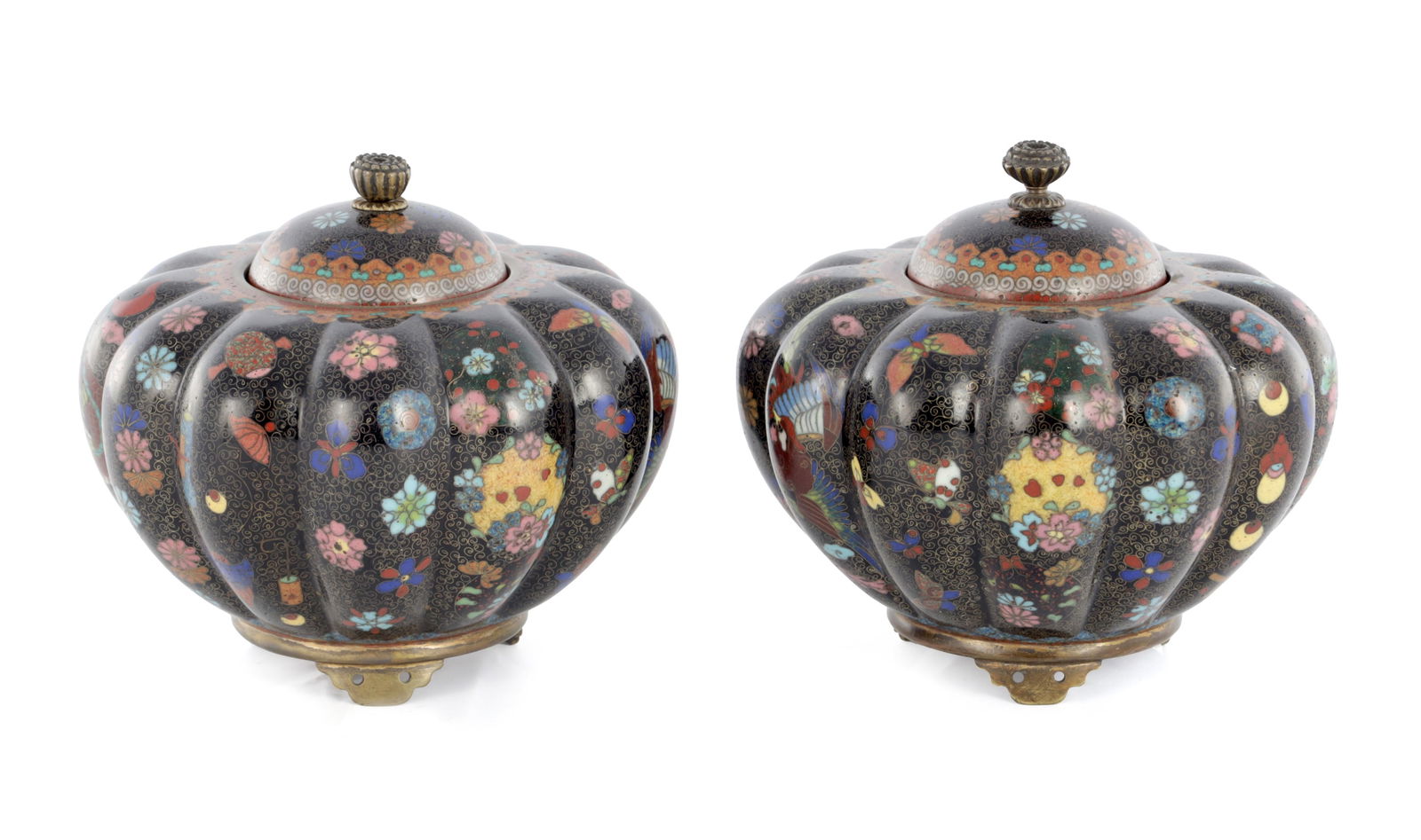 A PAIR OF JAPANESE MEIJI PERIOD CLOISONNE VASES AND COVERS: A PAIR OF JAPANESE MEIJI PERIOD CLOISONNE VASES AND COVERS of squat fluted form with domed lid decorated with intricate floral, bird and insect wirework on a black enamel ground; standing on three pie