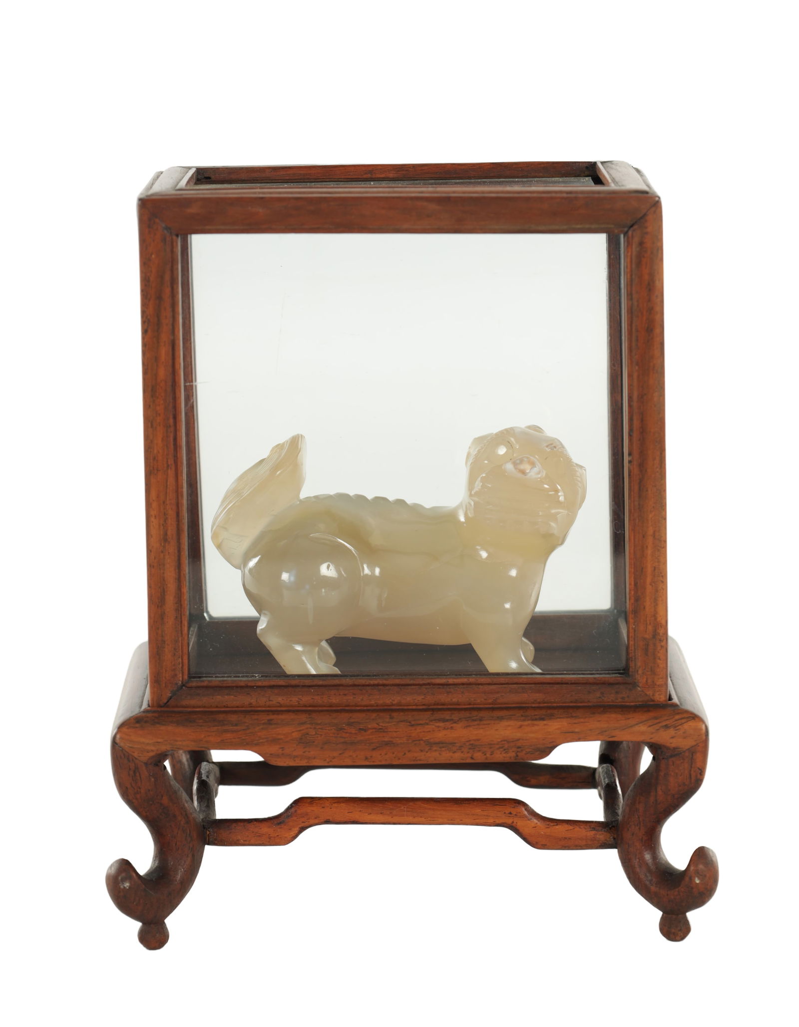 A CHINESE JADE CARVED SCULPTURE: A CHINESE JADE CARVED SCULPTURE formed as a Foo Dog with russeted jade to the head and tail of the Foo Dog - mounted on a wooden stand with a glass case. (9.5cm wide and 6cm high)