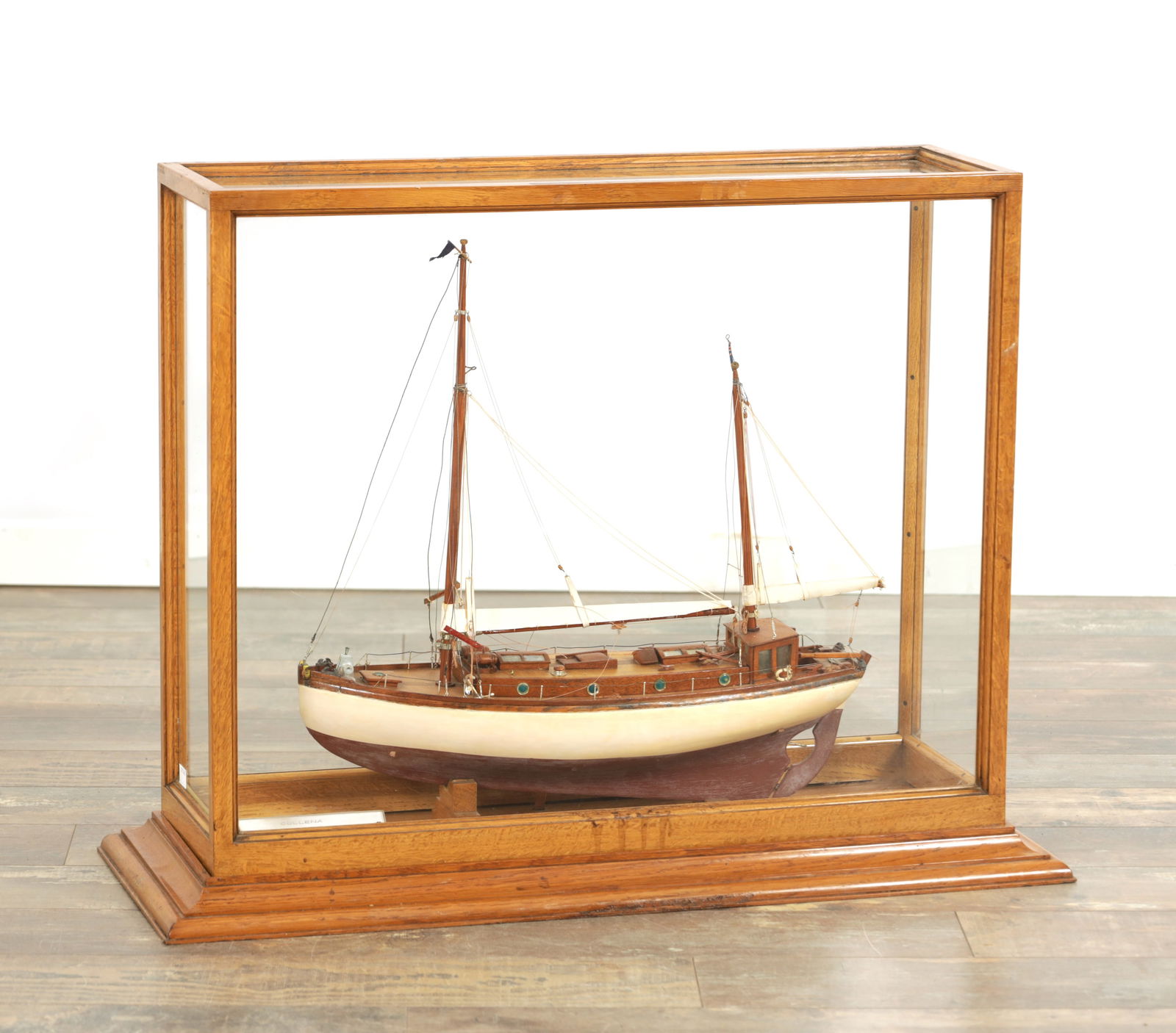 A 20TH CENTURY MODEL OF A SAILING YACHT "THE COLLENA": A 20TH CENTURY MODEL OF A SAILING YACHT "THE COLLENA" bearing plaque - Built at Dickies Yard, Tarbert 1912. During the 1939-45 war, she was used in the Clyde Patrol. in a glazed honey coloured oak cas