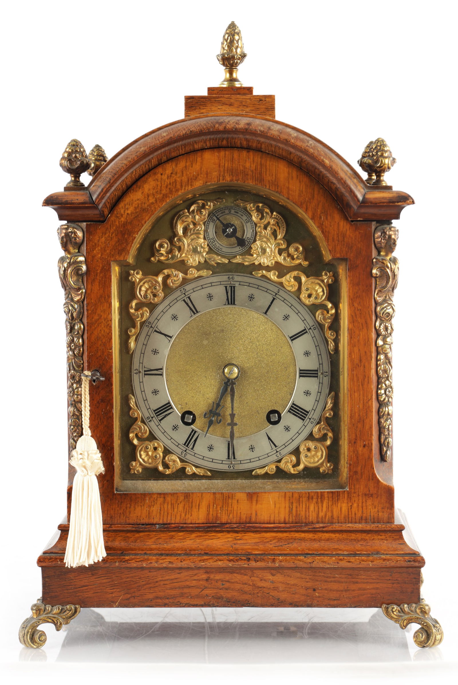 A LATE 19TH CENTURY GERMAN OAK CASED QUARTER CHIMING BRACKET CLOCK: A LATE 19TH CENTURY GERMAN OAK CASED QUARTER CHIMING BRACKET CLOCK, the arched case with ormolu caryatid canted corners enclosing a brass dial with gilt spandrels and silvered chapter ring surrounding