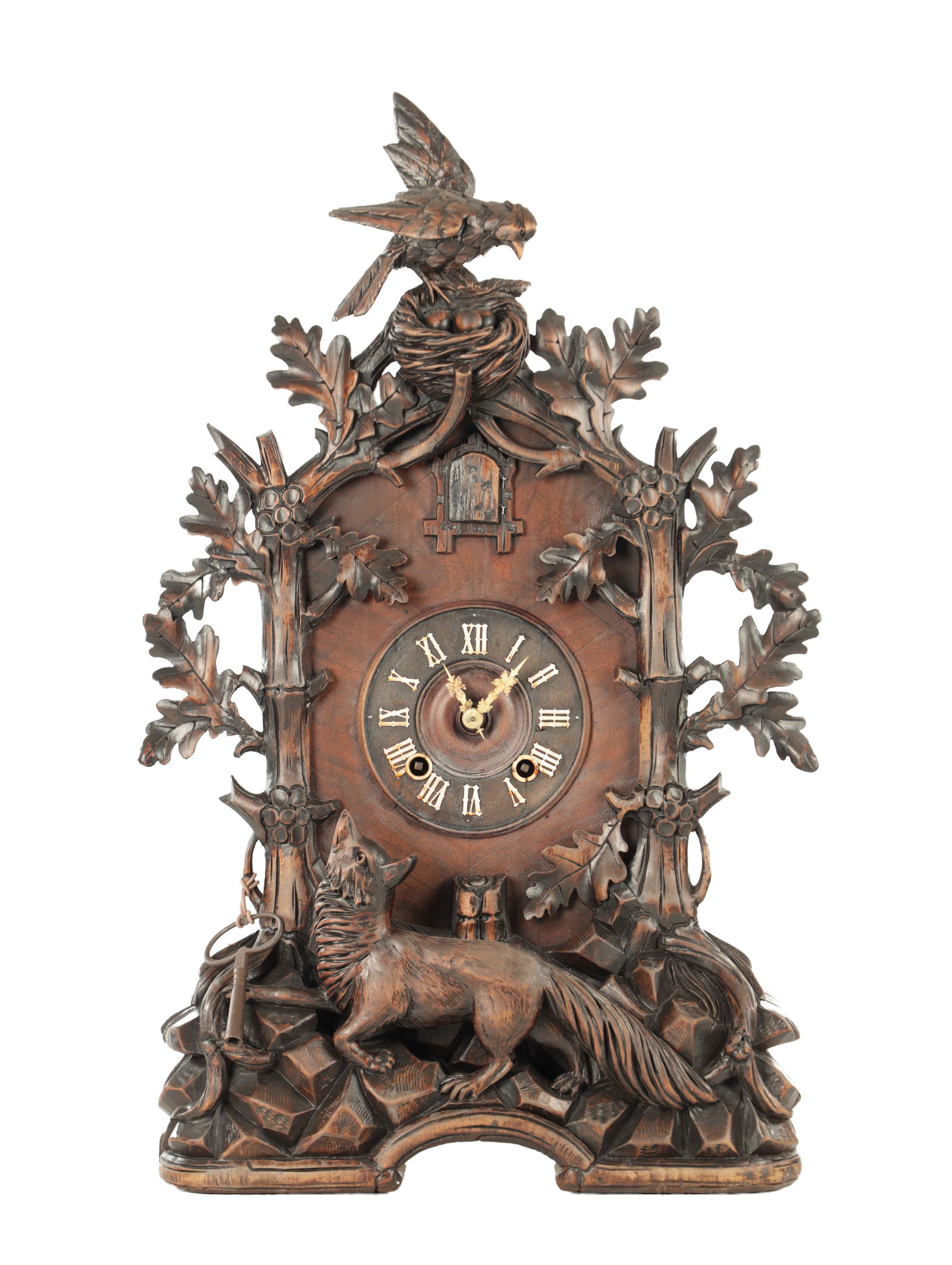 A 19TH CENTURY BLACK FOREST CARVED LINDEN WOOD CUCKOO MANTEL CLOCK: A 19TH CENTURY BLACK FOREST CARVED LINDEN WOOD CUCKOO MANTEL CLOCK the leaf-carved case with fox and bird surmounts, the dial having cut-out bone Roman numerals and pierced hands, fronting a spring-dr