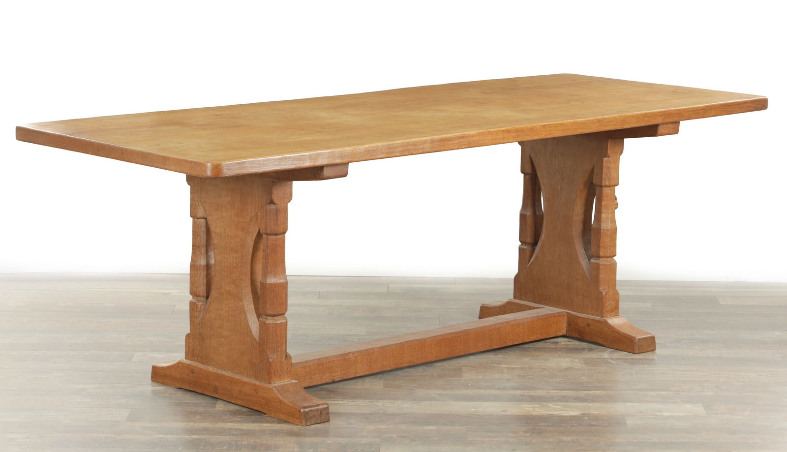 A RARE ROBERT MOUSEMAN THOMPSON SPECIAL ORDER OAK REFECTORY TABLE: A RARE ROBERT MOUSEMAN THOMPSON SPECIAL ORDER OAK REFECTORY TABLE with dowled plank top above an uniquely designed base having turned and shaped solid end supports joined by a bottom stretcher having
