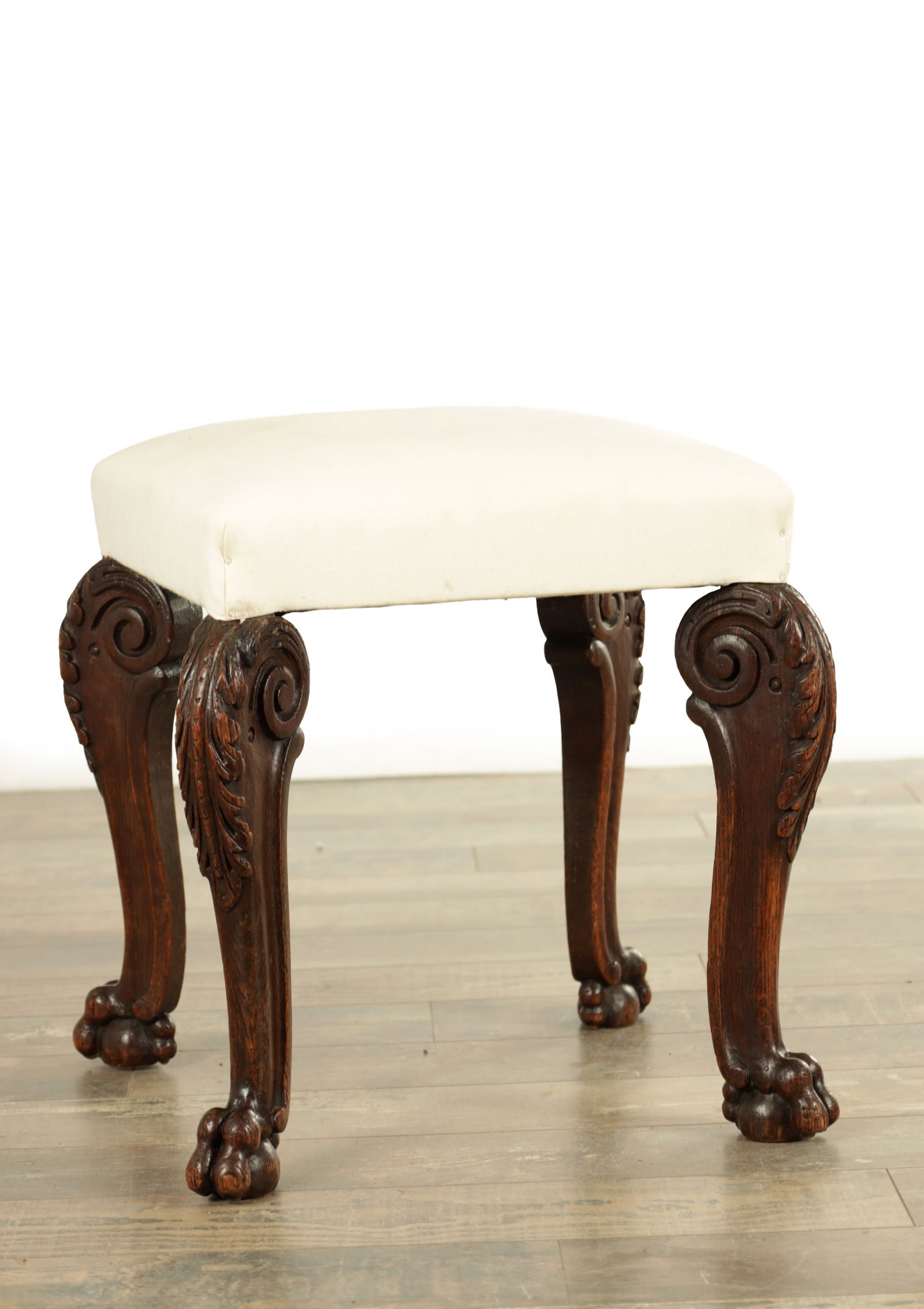 AN EARLY 18TH CENTURY CARVED ASH STOOL IN THE MANNER OF WILLIAM KENT, ENGLISH, CIRCA 1730: AN EARLY 18TH CENTURY CARVED ASH STOOL IN THE MANNER OF WILLIAM KENT, ENGLISH, CIRCA 1730 with scrolled leaf carved cabriole legs having ball and claw feet.(44cm square 45cm high )