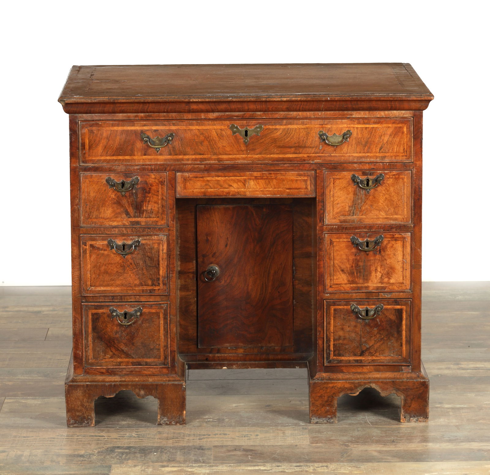 AN EARLY 18TH CENTURY FIGURED WALNUT AND HERRING-BANDED KNEEHOLE DESK (1 of 9)