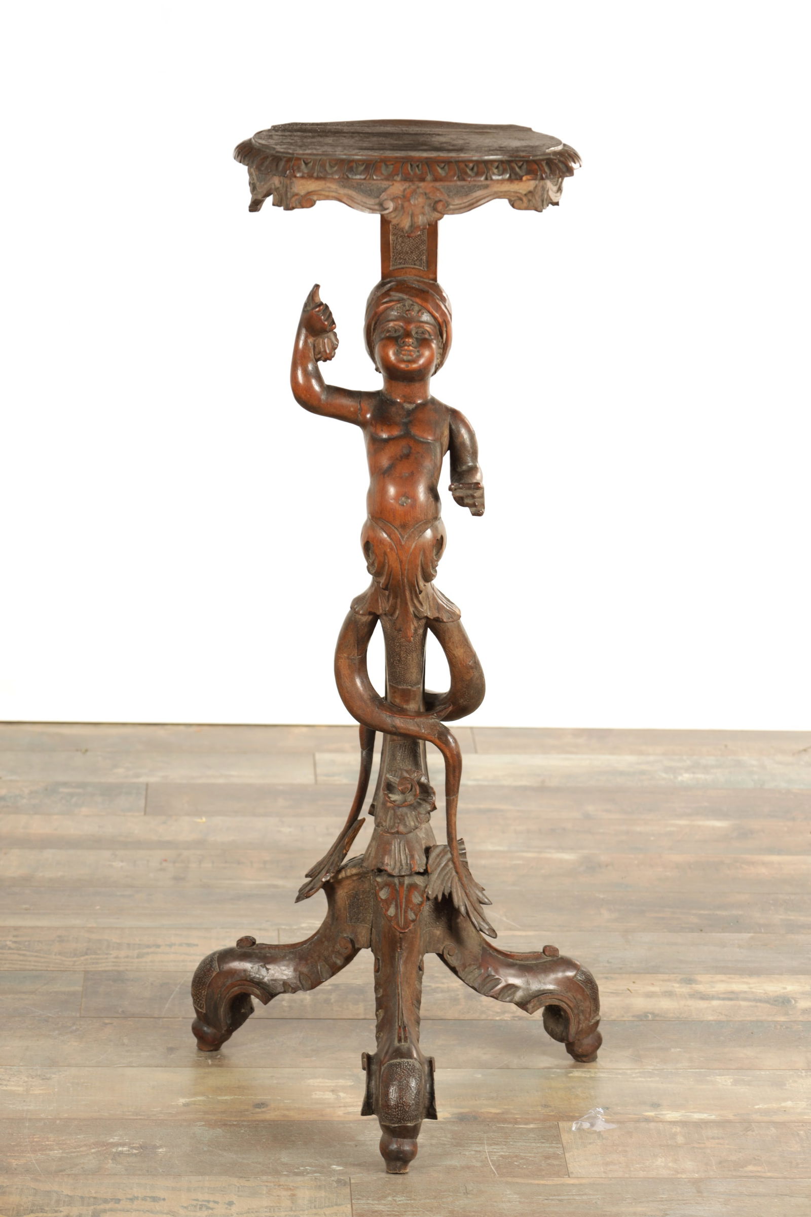 A 19TH CENTURY ITALIAN CARVED WALNUT FIGURAL JARDINIERE STAND: A 19TH CENTURY ITALIAN CARVED WALNUT FIGURAL JARDINIERE STAND with figural stem and leaf-carved shaped feet. (99cm high)