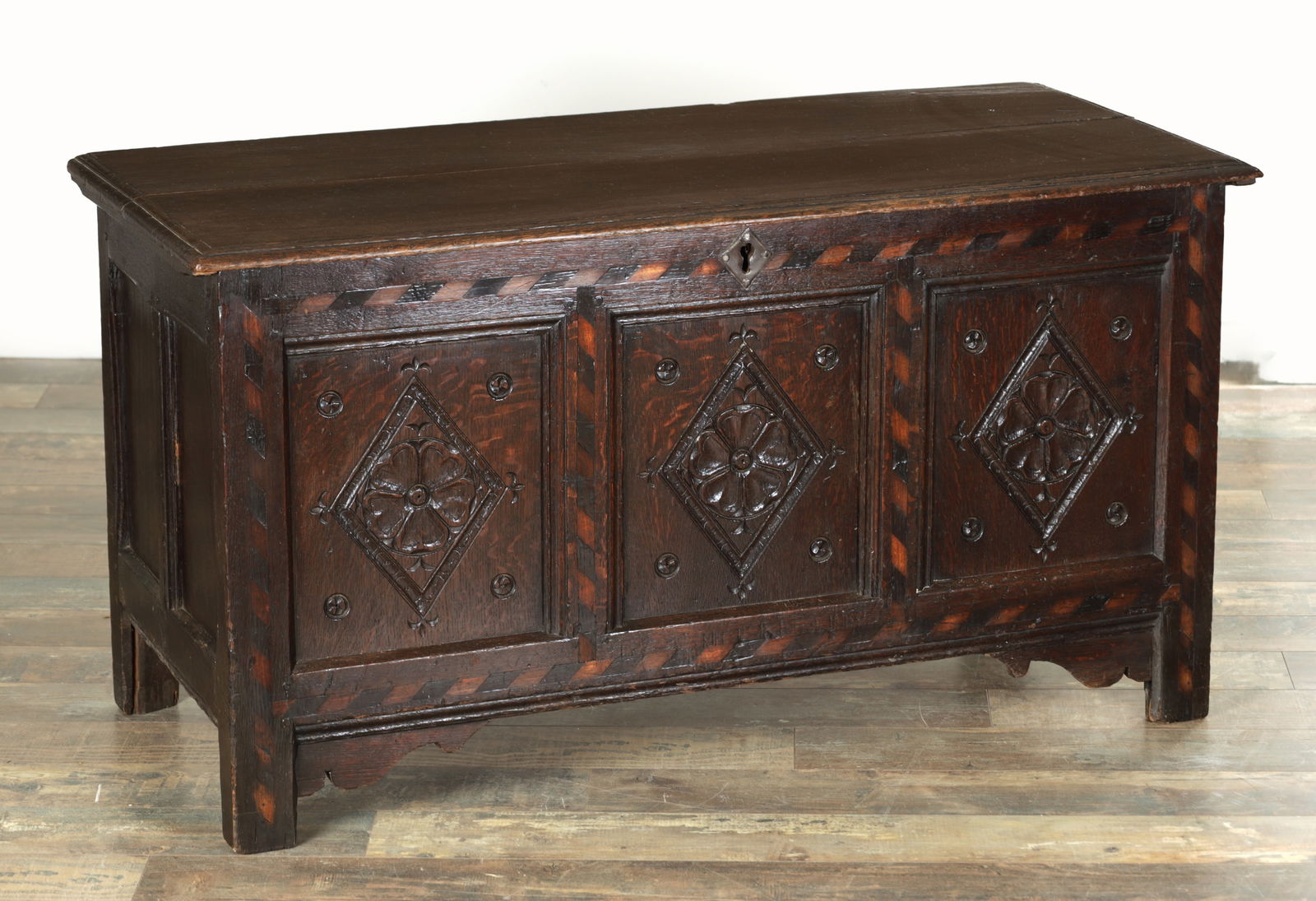 A 17TH CENTURY OAK PANELLED INLAID YORKSHIRE COFFER: A 17TH CENTURY OAK PANELLED INLAID YORKSHIRE COFFER with boarded top above three panels having carved lozenge centres and inlaid border. (119 cm wide 54 cm deep 63 cm high)