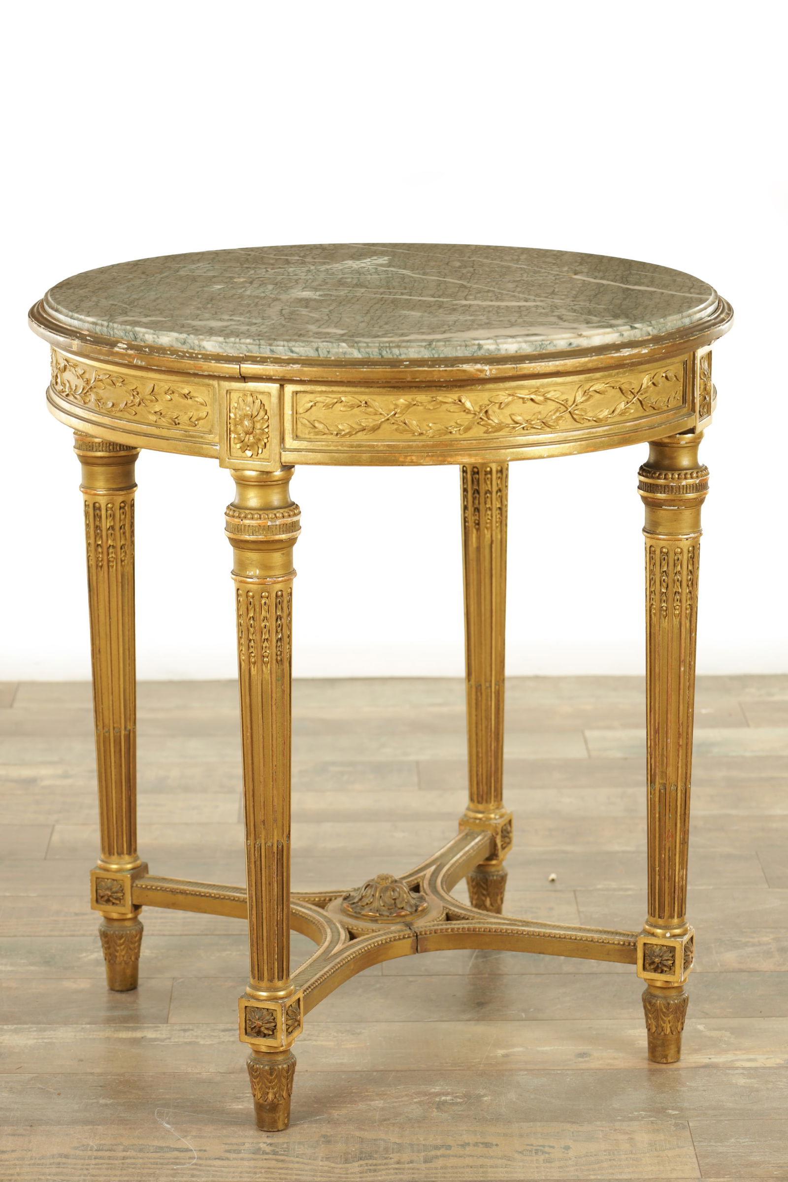 A 19TH CENTURY GILTWOOD CIRCULAR FRENCH OCCASIONAL TABLE: A 19TH CENTURY GILTWOOD CIRCULAR FRENCH OCCASIONAL TABLE with green veined marble top above leaf carved base with tapering leg supports (69cm diameter 76cm high )