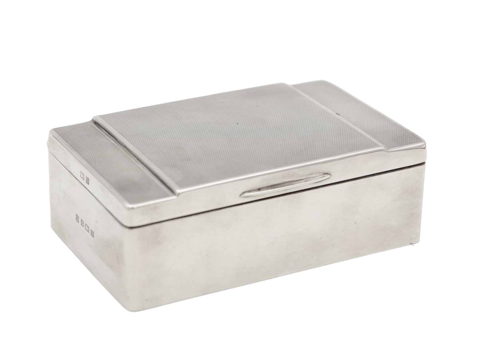 A MID 20TH CENTURY ENGLISH SILVER ENGINE TURNED CIGARETTE BOX: A MID 20TH CENTURY ENGLISH SILVER ENGINE TURNED CIGARETTE BOX of rectangular form with a hinged lid, the cover with engine turned decoration and raised bands, the front with a shaped thumbpiece, the i