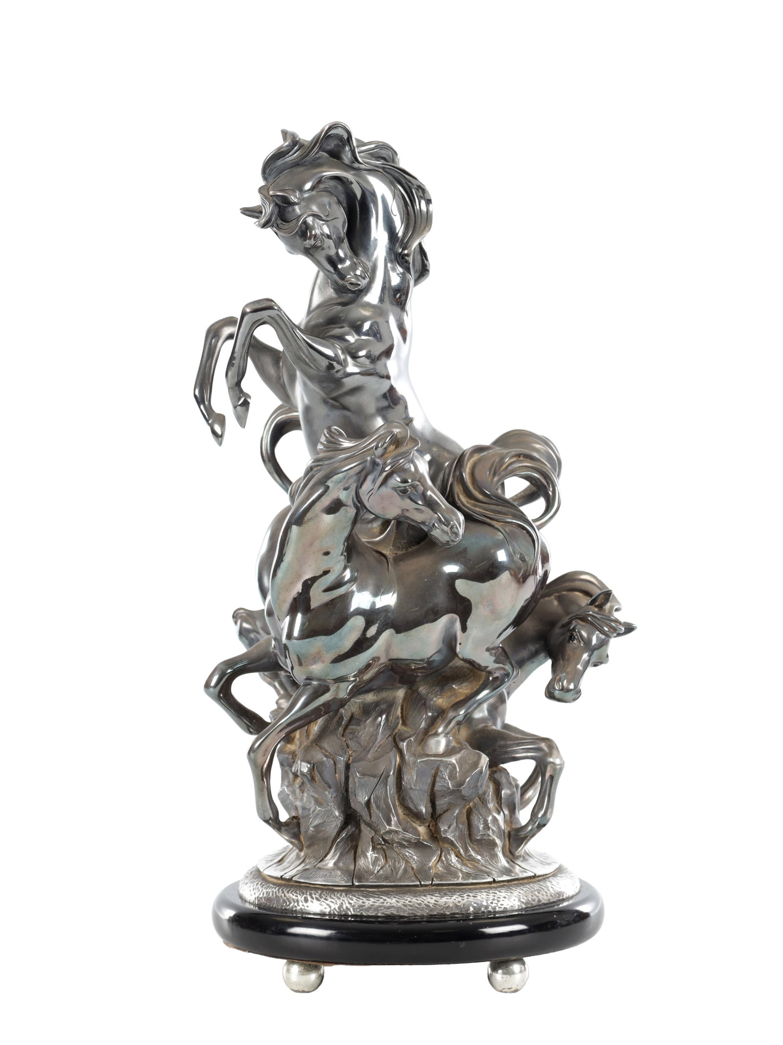 OTTAVIANI, ITALIAN 20TH CENTURY A SILVER FILLED EQUESTRIAN GROUP SIGNED AND STAMPED 925 ON AN: OTTAVIANI, ITALIAN 20TH CENTURY A SILVER FILLED EQUESTRIAN GROUP SIGNED AND STAMPED 925 ON AN EBONISED BASE modelled as three spirited horses rearing on a rocky outcrop, the ebonised plinth with a tex