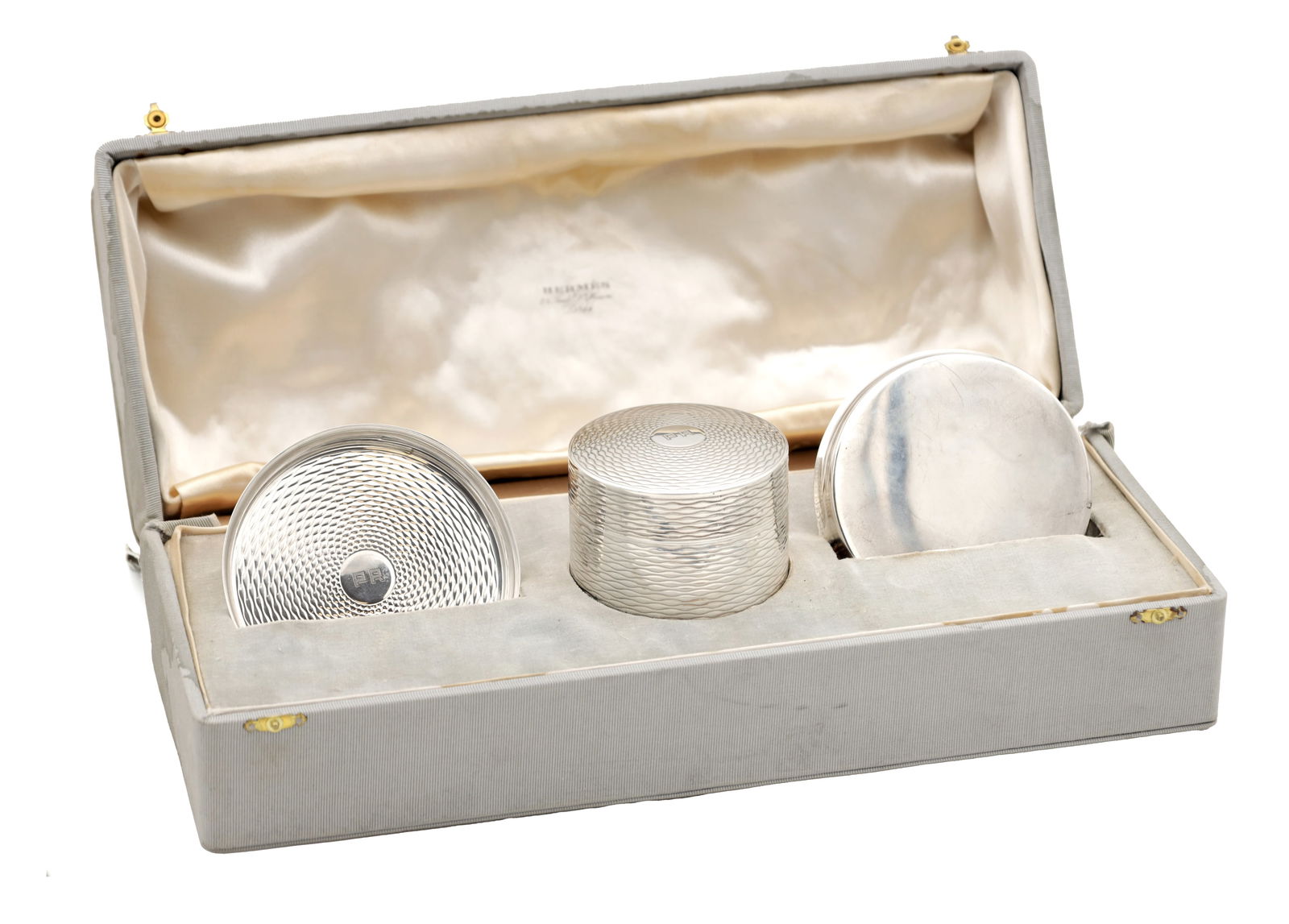 AN EARLY 20TH CENTURY FRENCH SILVER AND SILVER GILT HERMES SMOKERS SET: AN EARLY 20TH CENTURY FRENCH SILVER AND SILVER GILT HERMES SMOKERS SET comprising two circular ashtrays and a cylindrical cigarette box, all with engine-turned decoration and initialled centres, in th