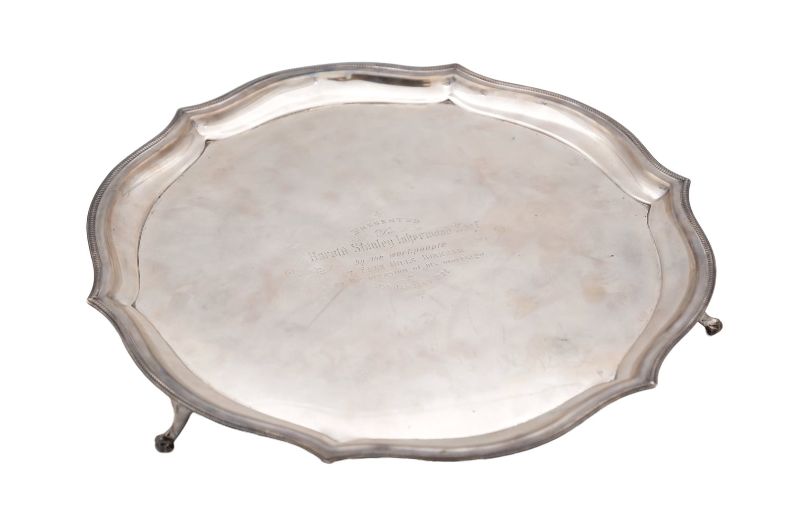 AN EARLY 20TH CENTURY SILVER SALVER: AN EARLY 20TH CENTURY SILVER SALVER with a raised moulded border raised on three feet, with an inscription to the centre. Total weight app. 760g - Sheffield, 1924. (30cm diameter)