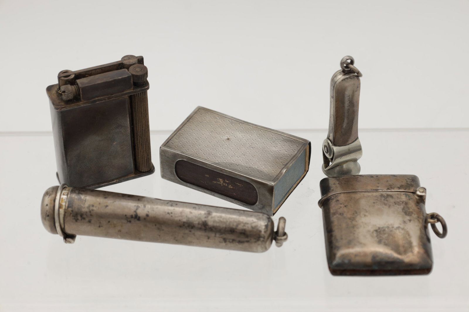 A COLLECTION OF FOUR ENGLISH SILVER SMOKING ACCESSORIES: A COLLECTION OF FOUR ENGLISH SILVER SMOKING ACCESSORIES comprising a cheroot case hallmarked Birmingham 1900, a vesta case hallmarked Birmingham 1911 and stamped PRO.PAT 831/09, a cheroot cutter stamp