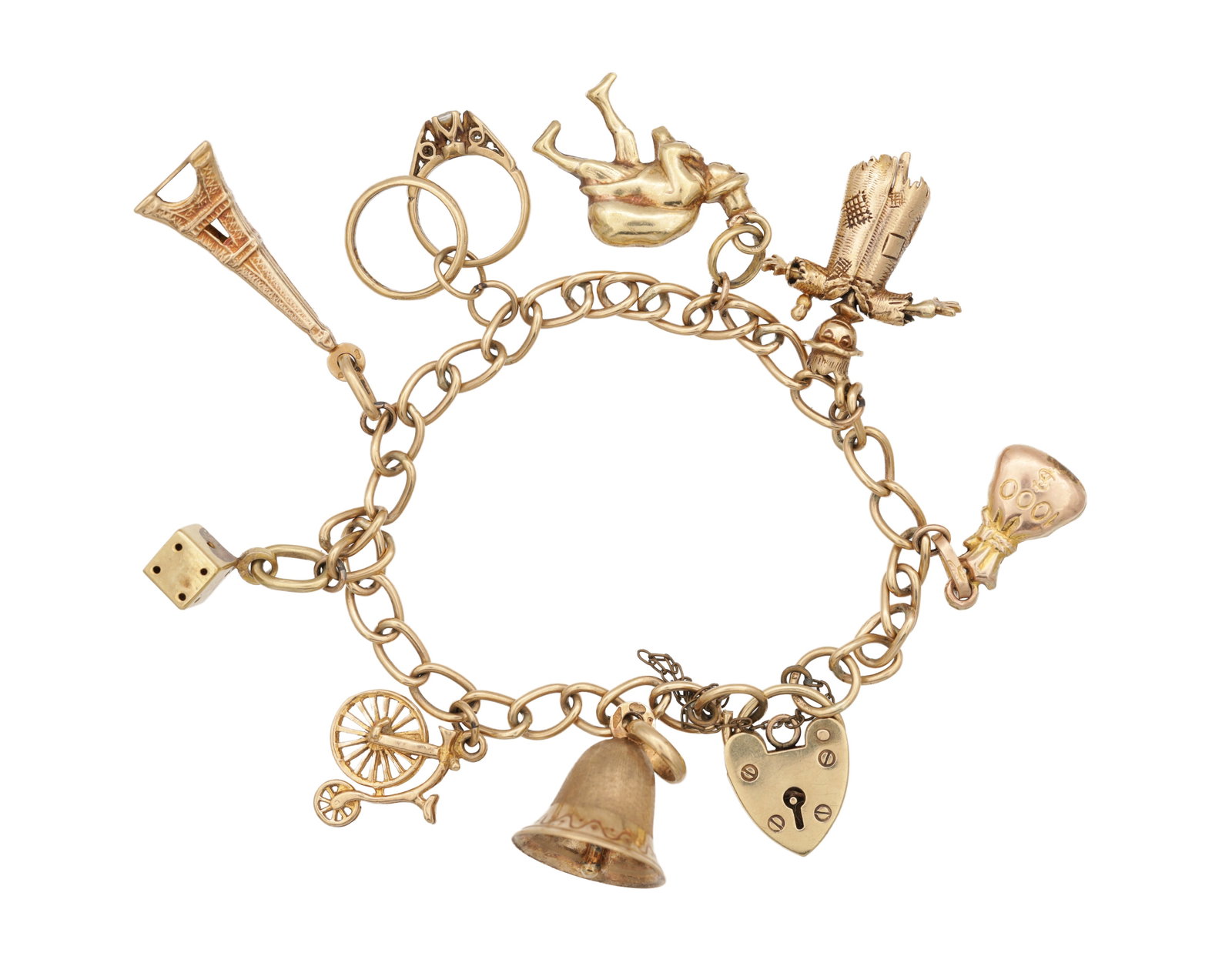 A 9CT YELLOW GOLD CHARM BRACELET WITH HEART PADLOCK CLASP: A 9CT YELLOW GOLD CHARM BRACELET WITH HEART PADLOCK CLASP with assorted charms including a bell, dice and penny-farthing, all charms hallmarked 375, total weight app. 19.7g. (Length of the bracelet 17