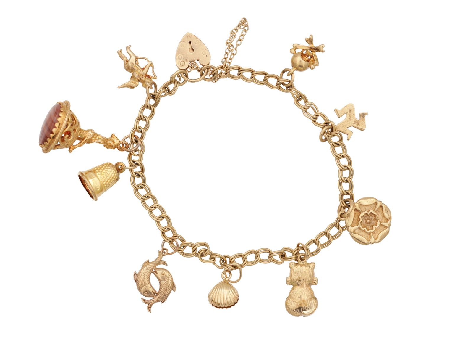 A 9CT YELLOW GOLD CHARM BRACELET: A 9CT YELLOW GOLD CHARM BRACELET all the charms hallmarked 375, fitted with assorted pendants including a carnelian set fob seal, thimble, Pisces, shell, teddy bear and rosehead, total weight app. 16.