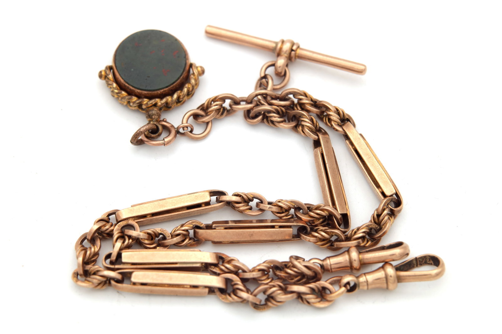 A 9CT ROSE GOLD DOUBLE ALBERT WATCH CHAIN WITH A BLOODSTONE AND AGATE FOB: A 9CT ROSE GOLD DOUBLE ALBERT WATCH CHAIN WITH A BLOODSTONE AND AGATE FOB with T-bar and twin dog clips, the fancy chain with baton and rope-twist links, suspending a swivel fob set with bloodstone an